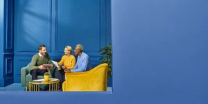 Financial professional meeting with a couple in their 50s in a bright office, discussing retirement planning