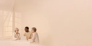 Wealth planner speaking with a couple in their fifties in a bright home office about healthcare savings and retirement
